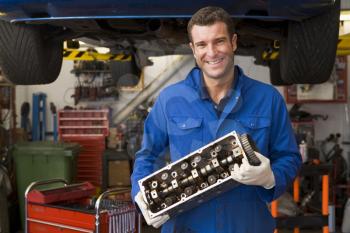Royalty Free Photo of a Mechanic With a Car Part