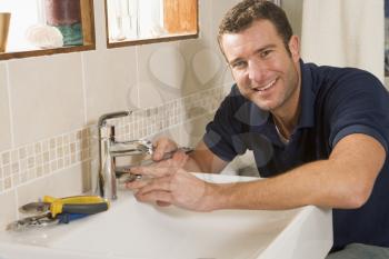 Royalty Free Photo of a Plumber Fixing a Sink