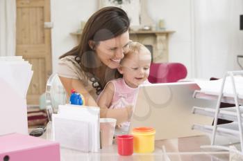 Royalty Free Photo of a Woman and Baby in a Home Office