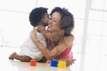 Royalty Free Photo of a Daughter Kissing Her Mother on the Floor
