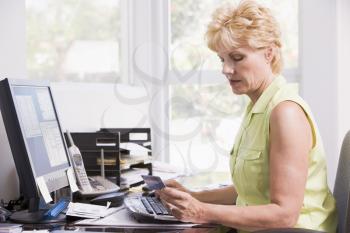 Royalty Free Photo of a Woman at a Computer Holding a Credit Card