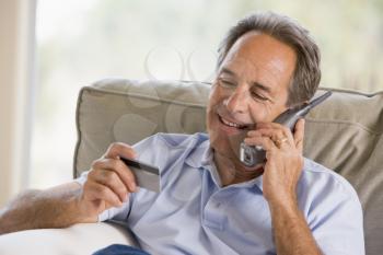 Royalty Free Photo of a Man on the Telephone Holding a Credit Card