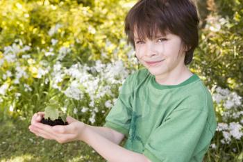 Royalty Free Photo of a Boy Holding a Plant