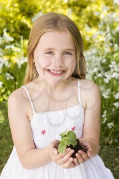Royalty Free Photo of a Child Holding a Plant