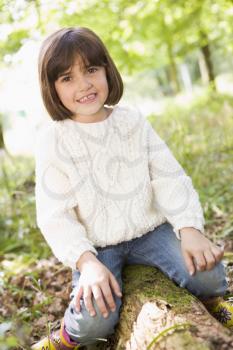 Royalty Free Photo of a Little Girl Sitting on a Log