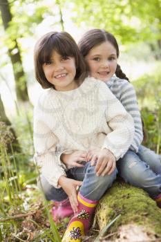 Royalty Free Photo of Two Girls Sitting on a Log