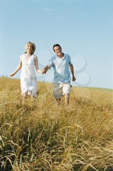 Royalty Free Photo of a Couple Walking in a Field