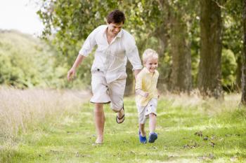 Royalty Free Photo of a Father and Son Running Outside