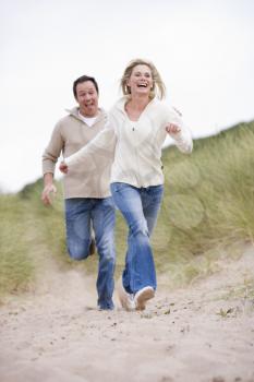 Royalty Free Photo of a Couple Running in Sand Dunes