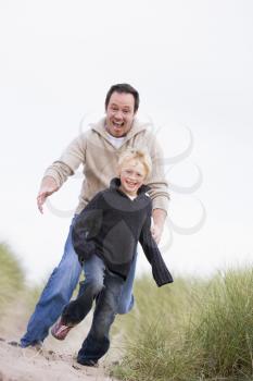 Royalty Free Photo of a Father and Son Running on Sand Dunes