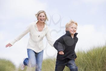 Royalty Free Photo of a Mother and Son Running on the Beach
