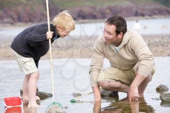 Royalty Free Photo of a Father and Son at the Beach Fishing