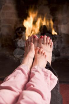 Royalty Free Photo of a Mother and Daughter Warming Her Feet at a Fire