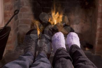 Royalty Free Photo of a Couple's Feet Warming at the Fire