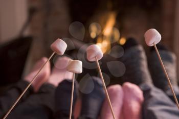 Royalty Free Photo of Feet Warming by a Fire and Marshmallows on Sticks