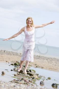 Royalty Free Photo of a Woman Walking on Rocks at the Beach