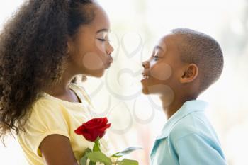 Royalty Free Photo of a Young Boy Giving a Girl Flowers