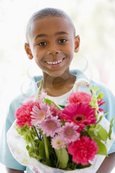 Royalty Free Photo of a Boy With a Bouquet of Flowers