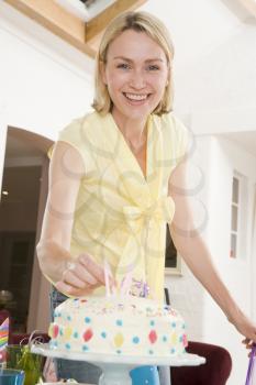 Royalty Free Photo of a Woman Putting Candles on a Cake
