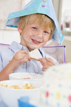 Royalty Free Photo of a Little Boy at a Birthday Party Eating a Sandwich