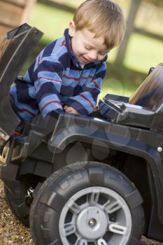 Royalty Free Photo of a Boy Playing With a Toy Jeep