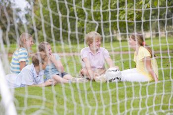 Royalty Free Photo of Kids on a Field Behind a Soccer Net
