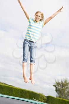 Royalty Free Photo of a Girl Jumping on a Trampoline