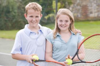 Royalty Free Photo of a Boy and Girl on a Tennis Court
