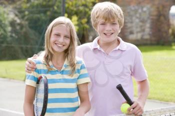 Royalty Free Photo of a Boy and Girl on a Tennis Court