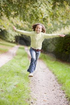 Royalty Free Photo of a Young Girl Running on a Path