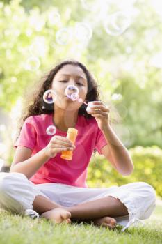 Royalty Free Photo of a Young Girl Blowing Bubbles