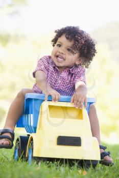 Royalty Free Photo of a Boy Riding on a Toy Dump Truck