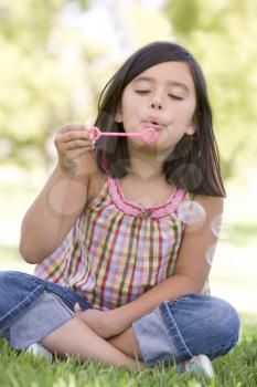 Royalty Free Photo of a Young Girl Blowing Bubbles