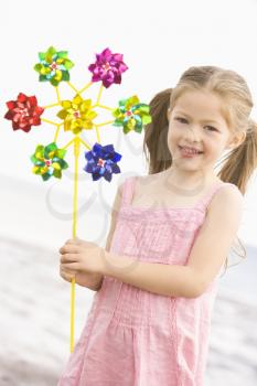 Royalty Free Photo of a Girl at the Beach With a Toy Windmill