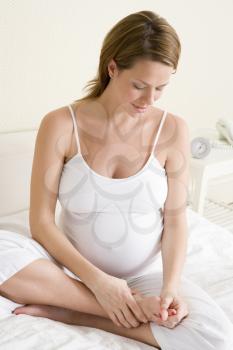 Royalty Free Photo of a Pregnant Woman Rubbing Her Feet