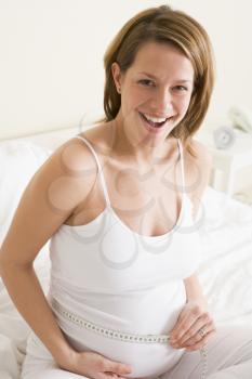 Royalty Free Photo of a Pregnant Woman Measuring Her Belly