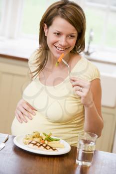 Royalty Free Photo of a Pregnant Woman Having Dinner