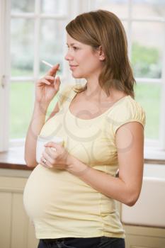 Royalty Free Photo of a Pregnant Woman Smoking and Drinking Coffee