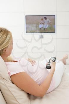 Royalty Free Photo of a Pregnant Woman Watching Television