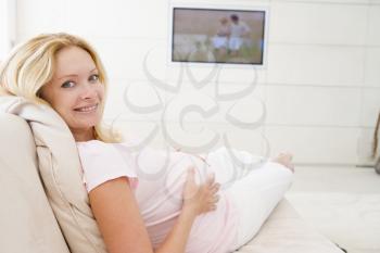 Royalty Free Photo of a Pregnant Woman Watching Television