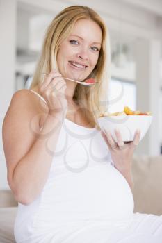 Royalty Free Photo of a Pregnant Woman Eating Fruit Salad