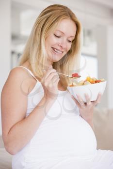 Royalty Free Photo of a Pregnant Woman Eating Fruit Salad