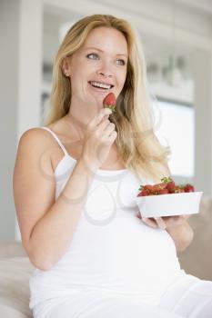 Royalty Free Photo of a Pregnant Woman Eating Strawberries
