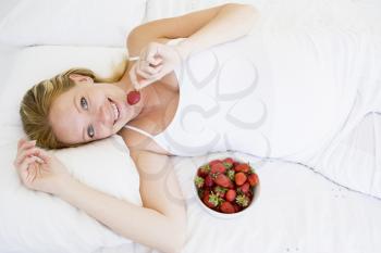 Royalty Free Photo of a Pregnant Woman in Bed With Strawberries