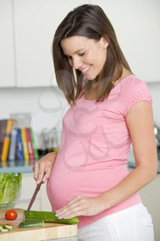 Royalty Free Photo of a Pregnant Woman Making a Salad