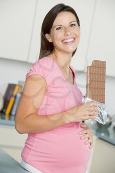 Royalty Free Photo of a Pregnant Girl With a Chocolate Bar