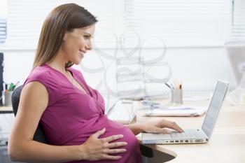 Royalty Free Photo of a Pregnant Woman With a Laptop