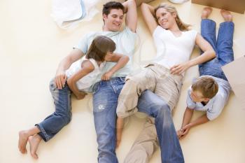 Royalty Free Photo of a Family Lying on the Floor Amid Boxes