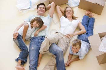 Royalty Free Photo of a Family Lying on the Floor Amid Unpacked Boxes