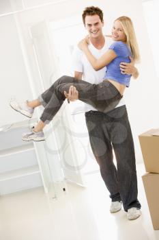 Royalty Free Photo of a Husband Carrying His Wife Over the Threshold